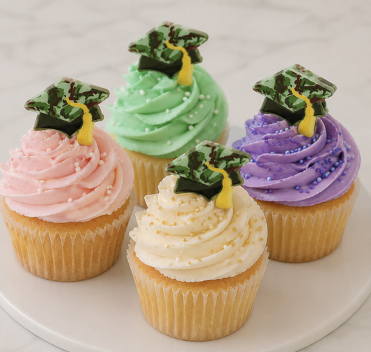 Four decorated cupcakes topped with military camouflage graduation cap rings in assorted buttercream colors. These reusable cupcake toppers are perfect for military graduations, ROTC celebrations, veteran family parties, and patriotic graduation desserts. Sold by the dozen at Bake A Cake.